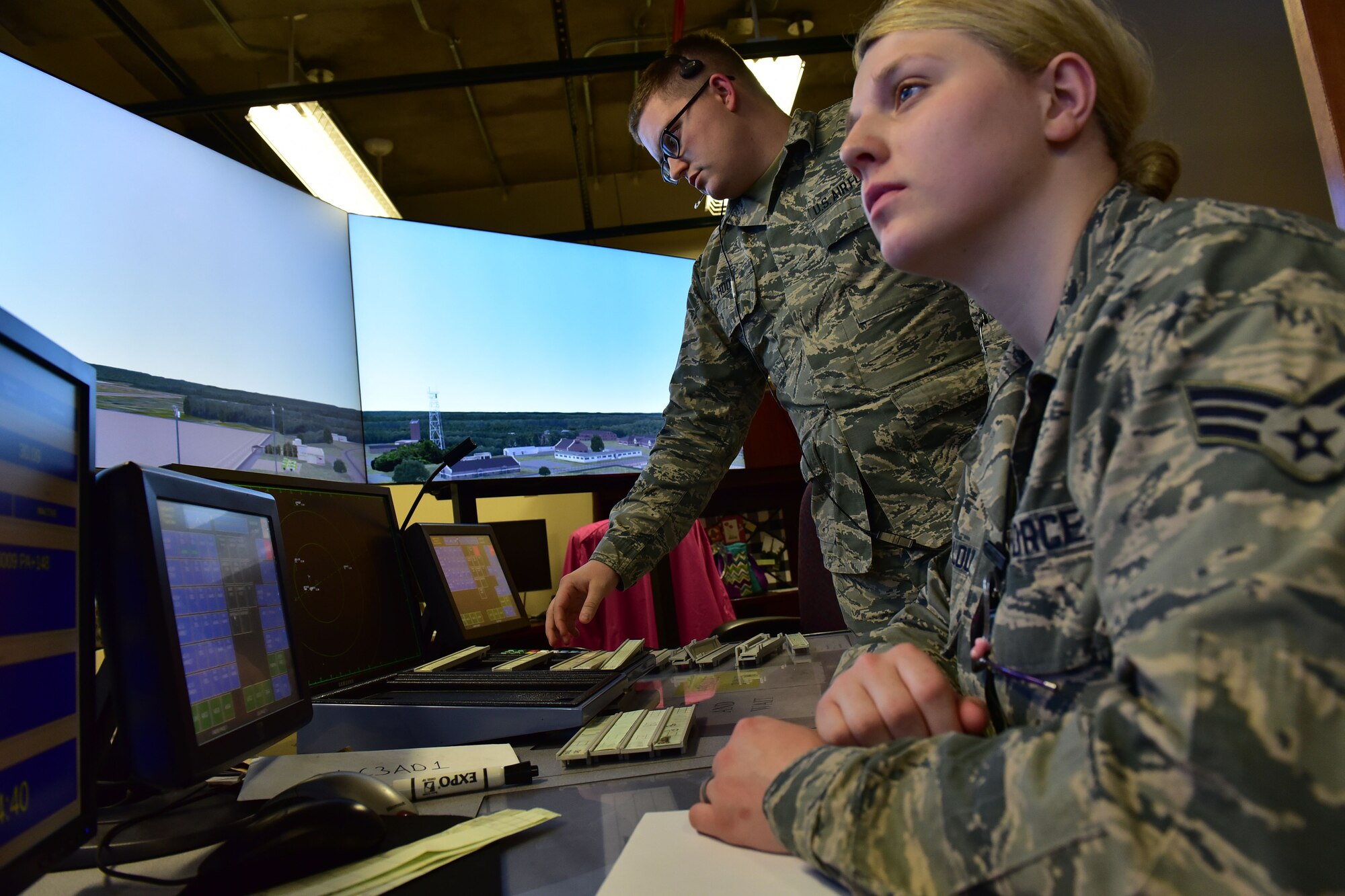 Senior Airman Gabriella Bellou, 19th Operations Support Squadron air traffic control journeyman, and Airman 1st Class Kyle Hood, 19th OSS air traffic control apprentice, use a simulator to assist Hood in his upgrade training Jan. 10, 2018, at Little Rock Air Force Base, Ark. The simulator is the primary tool used in air traffic control upgrade training, which can take up to a year. (U.S. Air Force photo by Airman 1st Class Rhett Isbell)