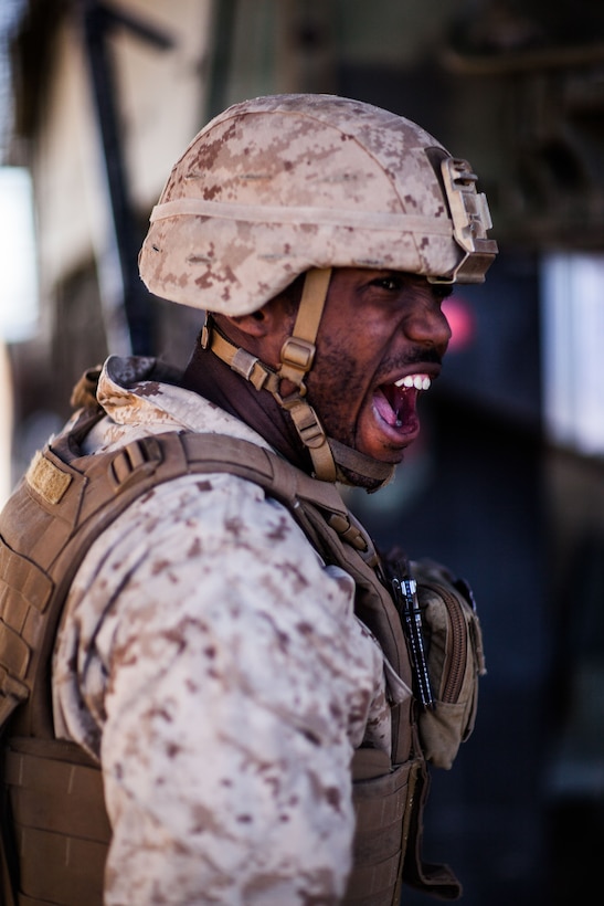 A Marine stands and shouts.