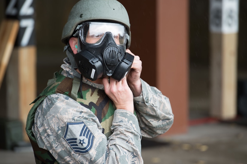 U.S. Air Force Master Sgt. Daniel Young, 1st Aircraft Maintenance Squadron production superintendent, dons a gas mask and helmet during training at the combat arms training and maintenance range at Joint Base Langley-Eustis, Va., Jan. 23, 2018.