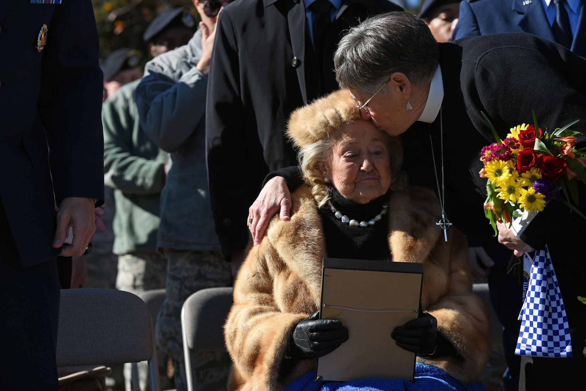 Reverend Susan Johnson kisses her mother, Jacqueline Heckel, on the forehead following a Prisoner of War Medal presentation for her late husband, Col. Charles C. Heckel, at Shaw Air Force Base, S.C., Jan. 19, 2018.