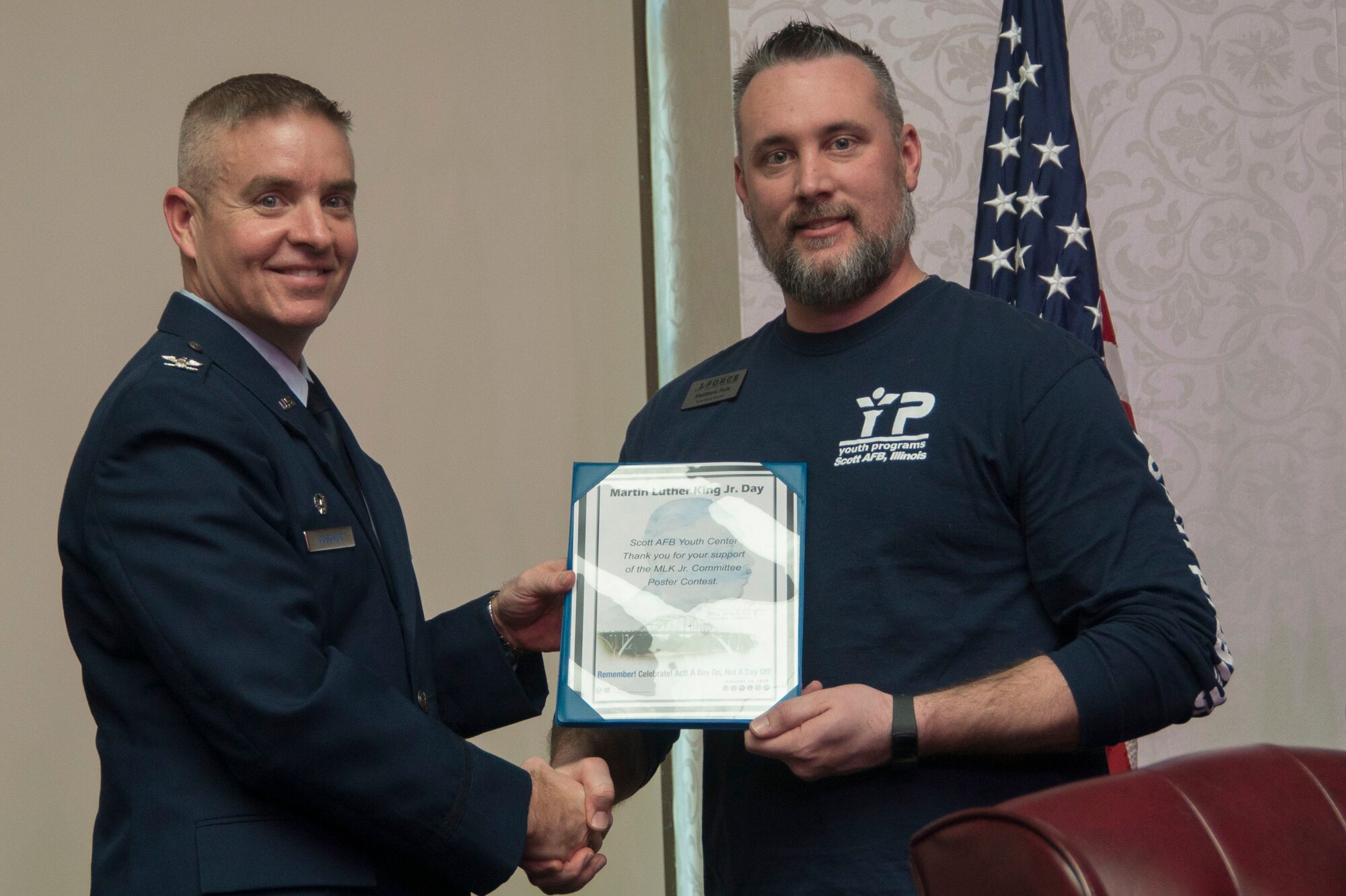 Col. Chris Buschur, 375th Air Mobility Wing commander, presents a certificate to the Scott Air Force Base Youth Center during the Dr. Martin Luther King, Jr., luncheon, Jan. 16, 2017, Scott AFB, Ill. Each room of the youth center participated in a poster design competition about what Dr. King’s legacy means. (U.S. Air Force photo by Senior Airman Melissa Estevez)