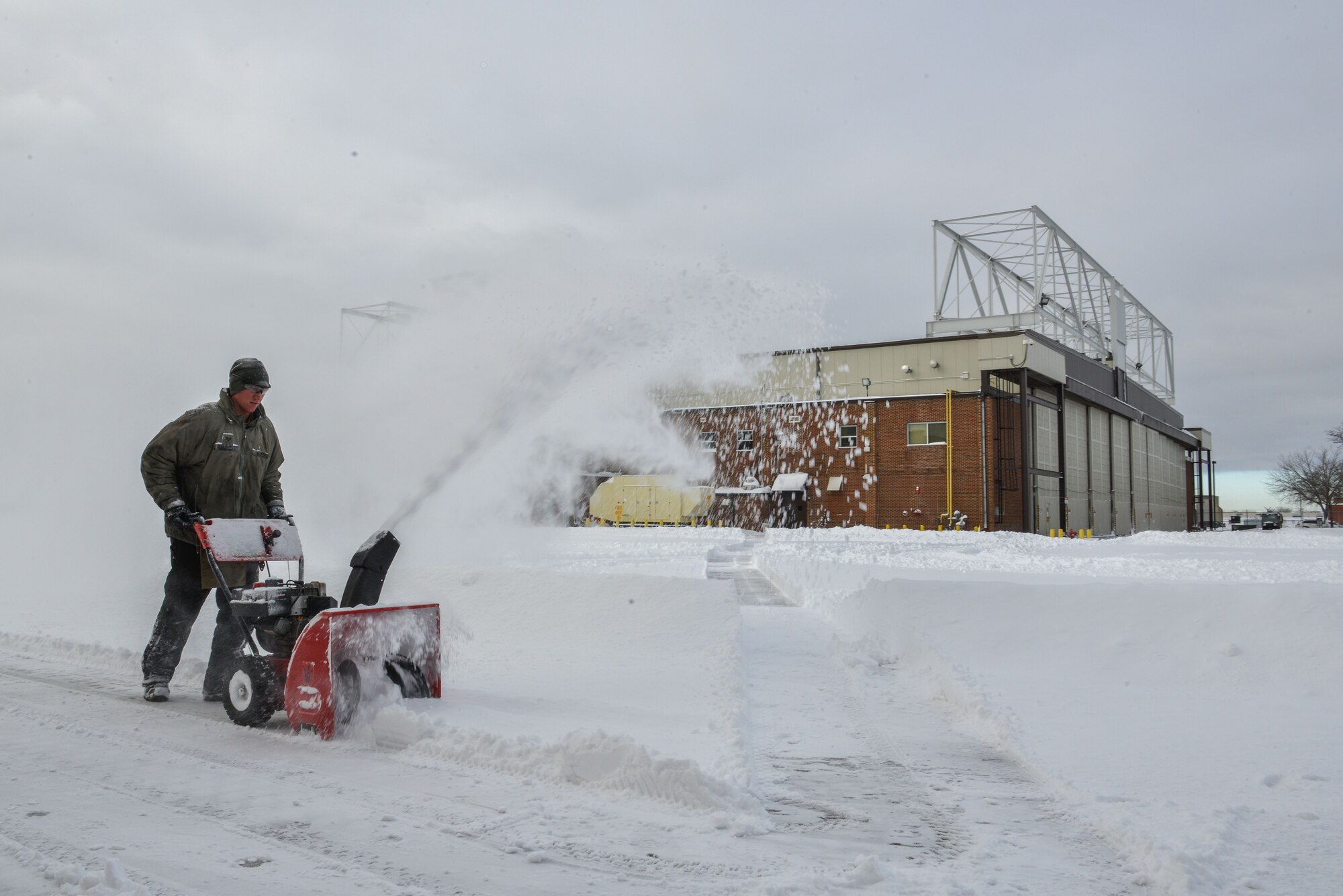 Tech. Sgt. Jeremy Schroeder, a hydraulics craftsman with the 934th Maintenance Squadron, uses a snowblower to clear a path near the hangars at the Minneapolis-St. Paul Air Reserve Station, Minn., on Jan. 23, 2018. Members of the wing spent the better part of the day digging out from approximately 10 to 12 inches of snow left after the storm. (U.S. Air Force photo by Master Sgt. Eric Amidon)