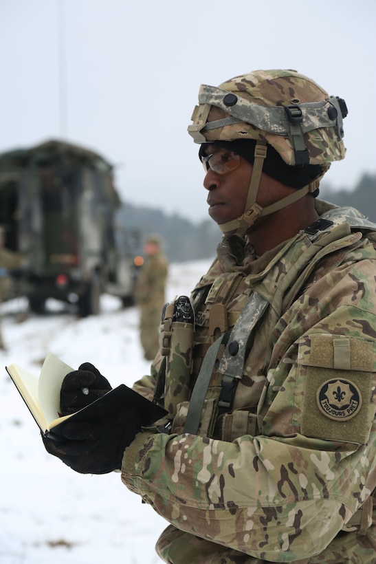 A soldier writes in a notebook.
