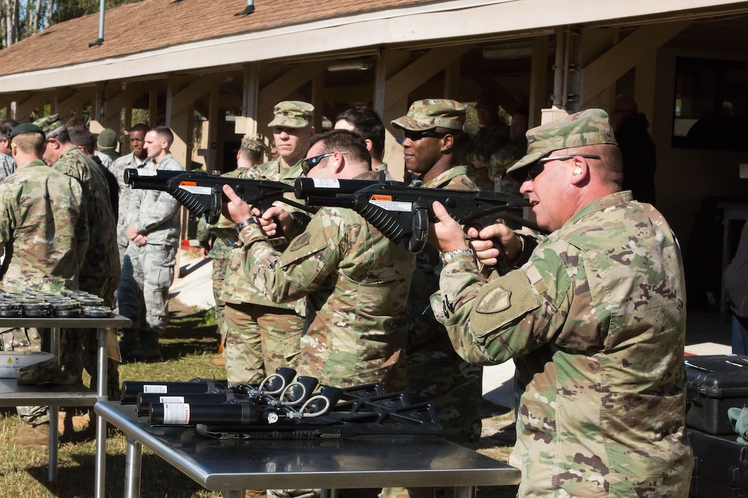 Joint service military personnel from U.S. Central Command (USCENTCOM) and supporting commands fire non-lethal weapons (NLW) at the MacDill Air force Base firing range during a familiarization event (FAMFIRE) Jan. 18, 2018. The FAMFIRE was a demonstration of NLW capabilities, and a show of how non-lethal weapons may be used in conjunction with lethal weapon systems to enhance effectiveness and efficiency in military operations. (Photo by Tom Gagnier)