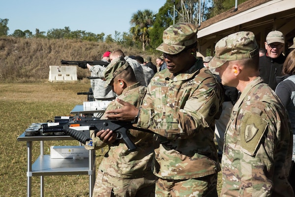U.S. Army MAJ Kendall Robinson, Division Chief, Capabilities and Requirements, Joint Non-Lethal Weapons Directorate shows a Soldier an FN303 compressed air launcher. Joint service military personnel from U.S. Central Command (USCENTCOM) and supporting commands had the opportunity to fire non-lethal weapons (NLW) at the MacDill Air Force Base firing range during a familiarization event (FAMFIRE), Jan. 18, 2018. The FAMFIRE was a demonstration of NLW capabilities, and a show of how NLW may be used in conjunction with lethal weapon systems to enhance effectiveness and efficiency in military operations. (Photo by Tom Gagnier)