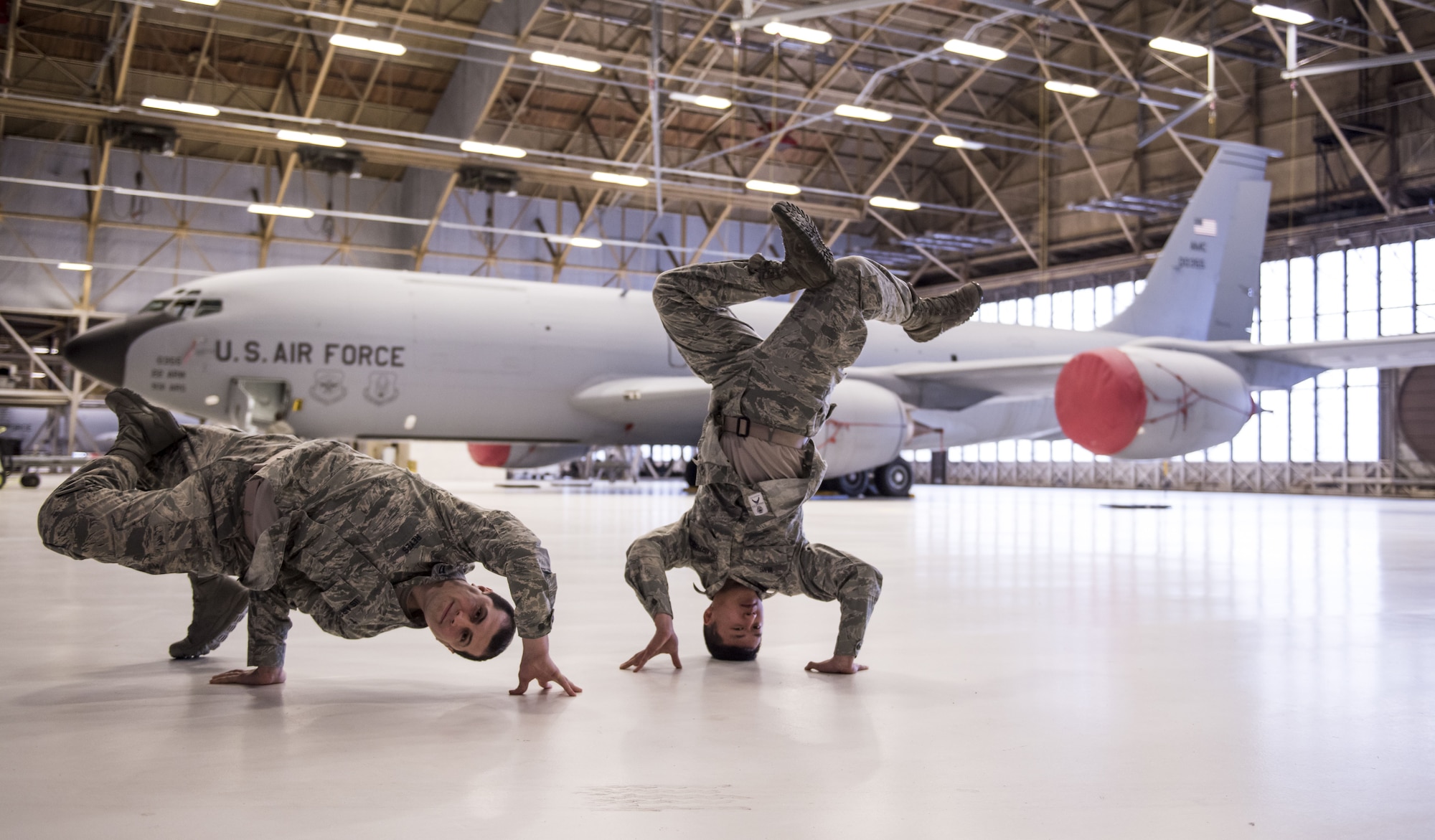 Capt. Juan Reyes, 92nd Air Refueling Wing chaplain, and Senior Airman Simon Vang, 92nd Maintenance Group analyst, break dance in front of a KC-135 Stratotanker, Fairchild Air Force Base, Wash., Jan. 18, 2018. Both Vang and Reyes started dancing in grade school and have fostered a passion for it, which in turn helps them with job performance and becoming more effective Airmen. (U.S. Air Force photo by Senior Airman Sean Campbell)