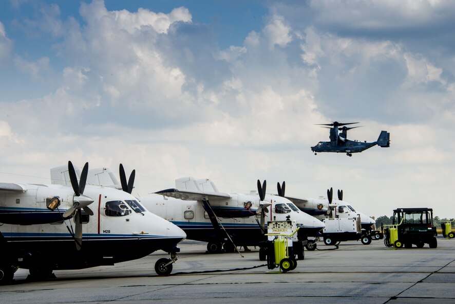 A CV-22 Osprey from Hurlburt Field, Fla. hovers over C-145 Skytrucks