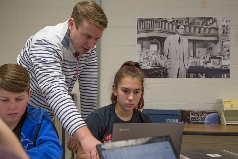 A teacher helps a student with an essay.