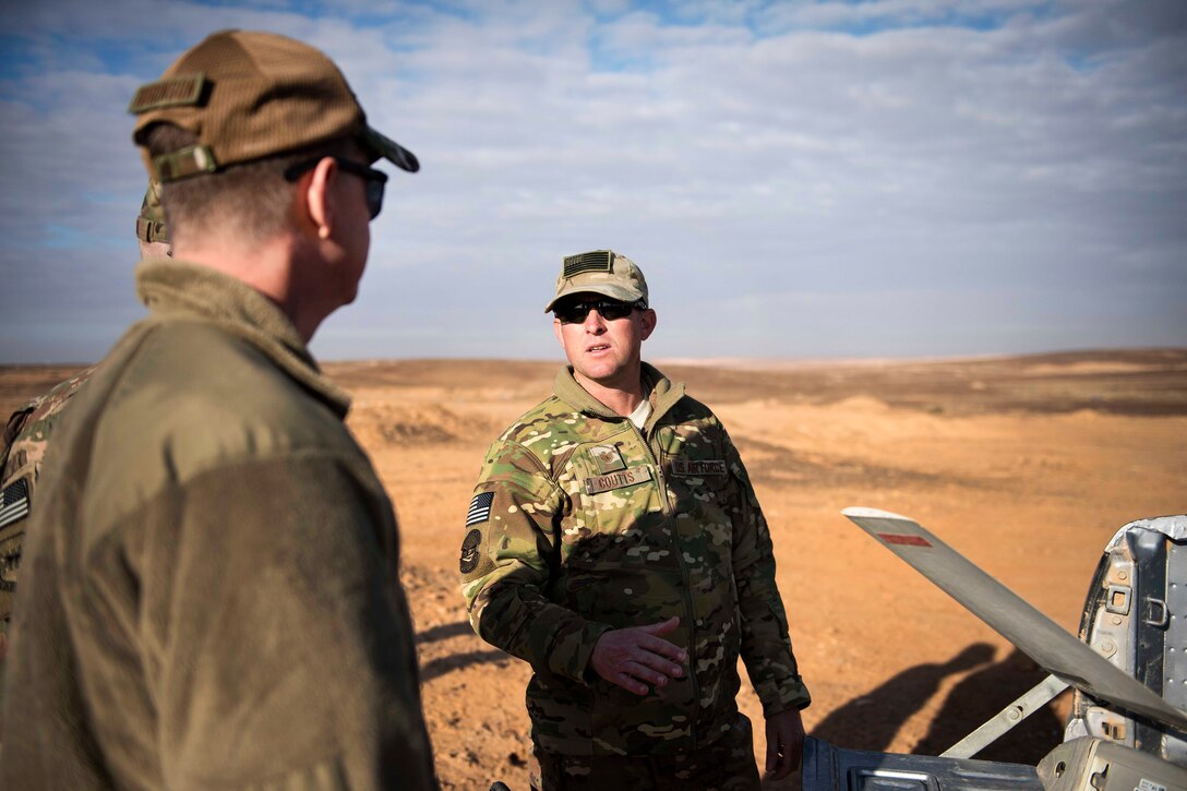 Air Force Tech Sgt. Matthew Coutts, right, explains the capabilities of the Raven B Digital Data Link drone for Air Force Brig. Gen. Kyle Robinson, commander, 332nd Air Expeditionary Wing, in Southwest Asia.