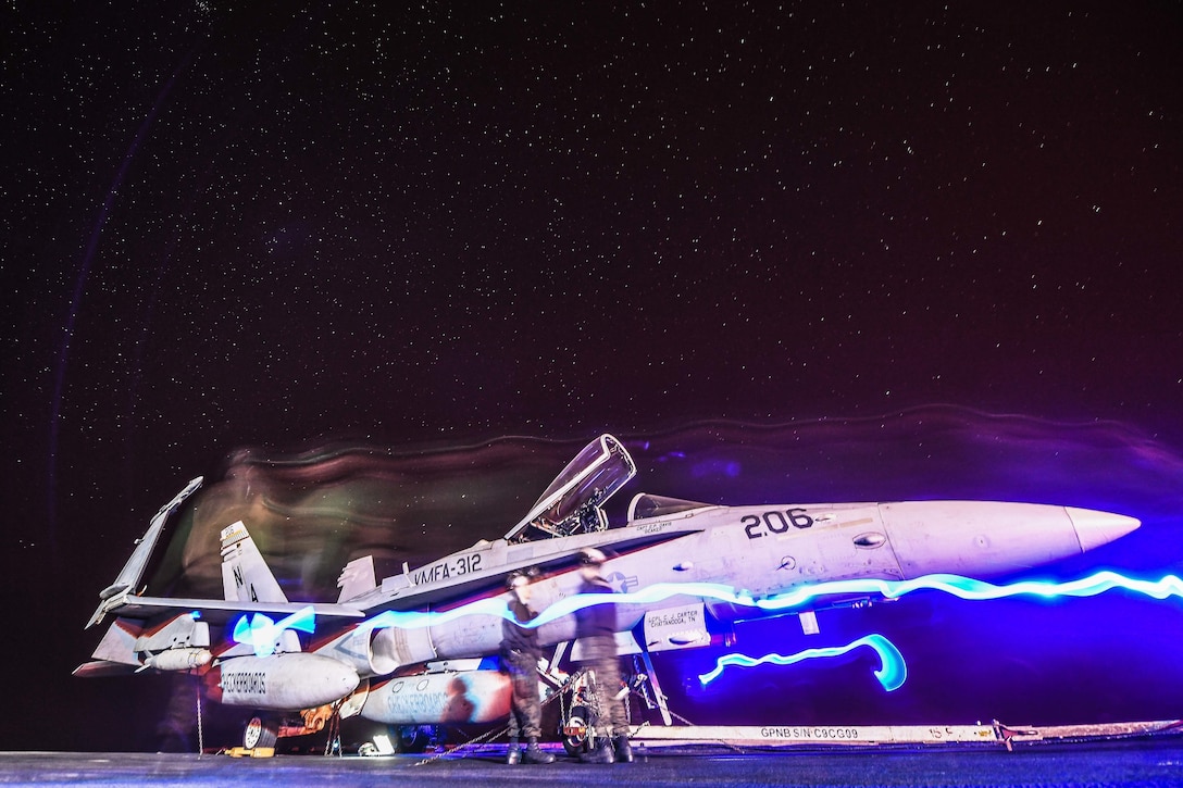 180124-N-MJ135-1024 ARABIAN GULF (Jan. 24, 2018) Marines move an F/A-18C Hornet, assigned to the Checkerboards of Marine Strike Fighter Attack Squadron (VMFA) 312, on the flight deck of the aircraft carrier USS Theodore Roosevelt (CVN 71). Theodore Roosevelt and its carrier strike group are deployed to the U.S. 5th Fleet area of operations in support of maritime security operations to reassure allies and partners and preserve the freedom of navigation and the free flow of commerce in the region. (U.S. Navy photo by Mass Communication Specialist 3rd Class Spencer Roberts/Released)