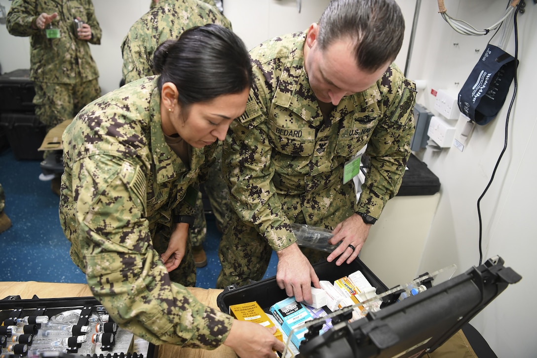 To sailors look through a medical kit.