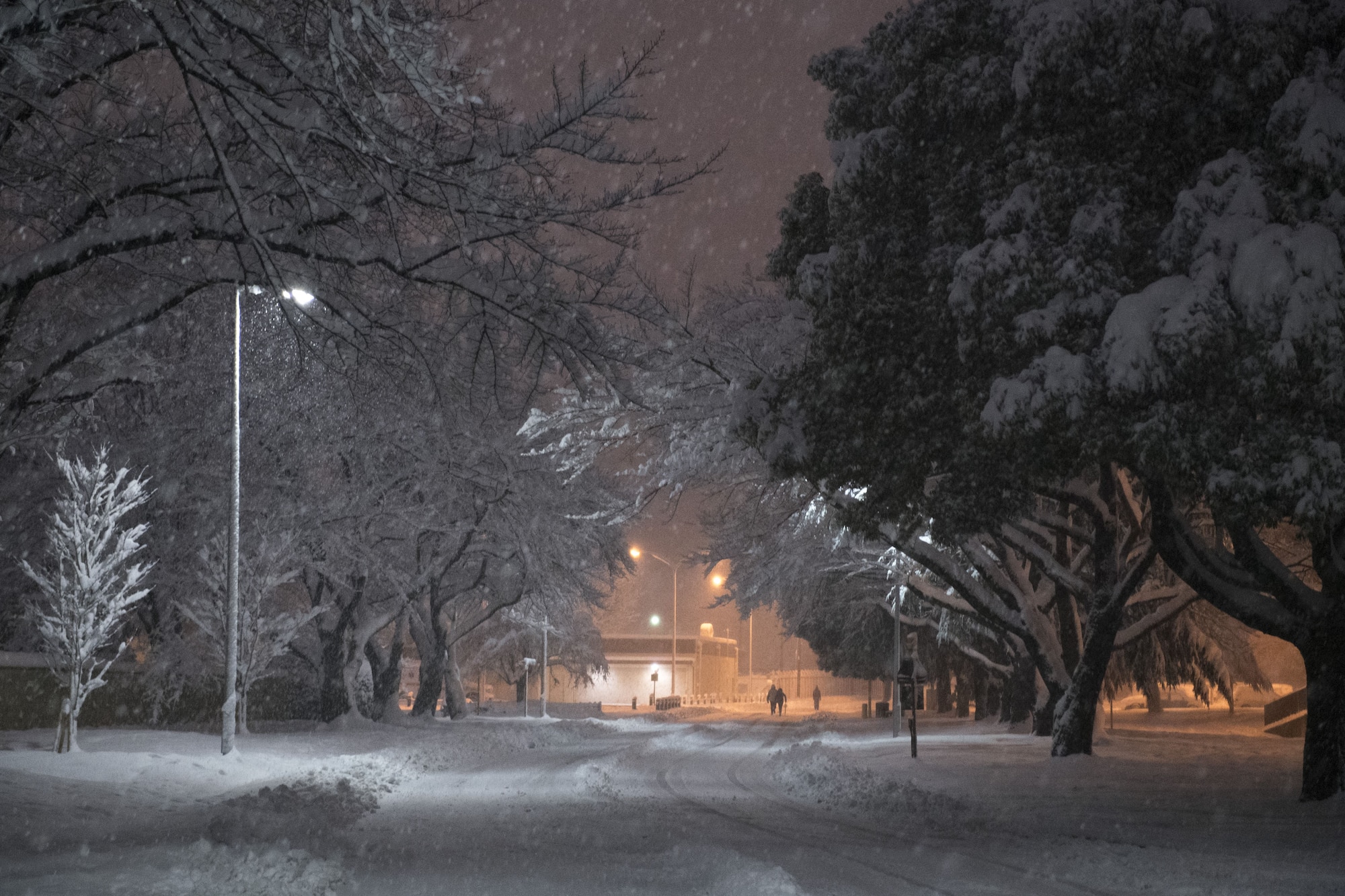 Base residents walk through the snow covered streets during the first snow storm of the year, Jan. 22, 2018, at Yokota Air Base, Japan.
