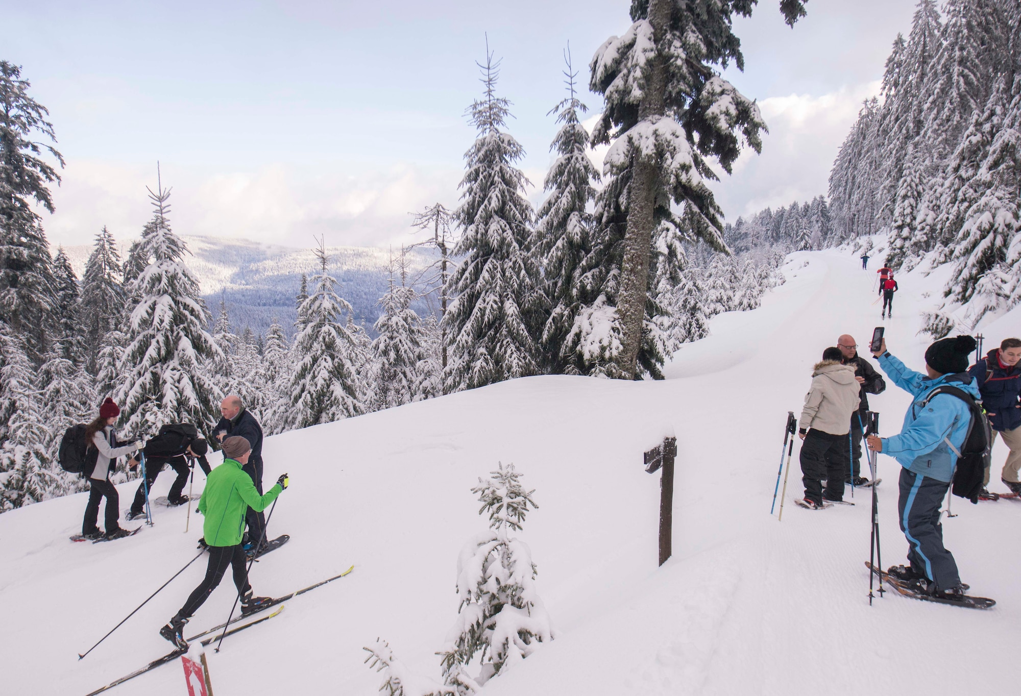 Snowshoe-hikers and skiers travel a path through the Black Forest, Sasbachwalden, Germany, Jan. 21, 2018. The 86th Force Support Squadron Outdoor Recreation took a group of participants on a snowshoe hike through the Black Forest, which is one of the many adventure trips they offer. (U.S. Air Force photo by Senior Airman Elizabeth Baker)