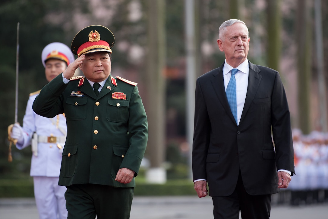 U.S. and Vietnamese defense leaders walk together in Vietnam.