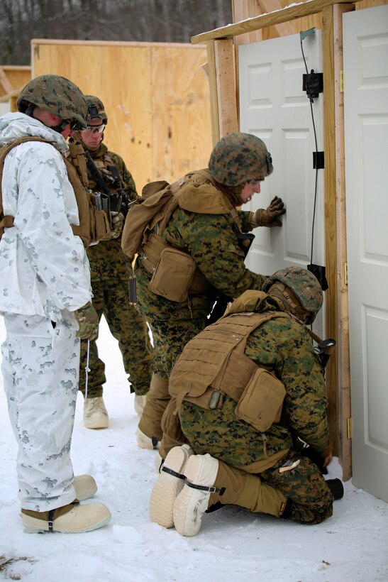 Marines prepare an explosive charge to a door.