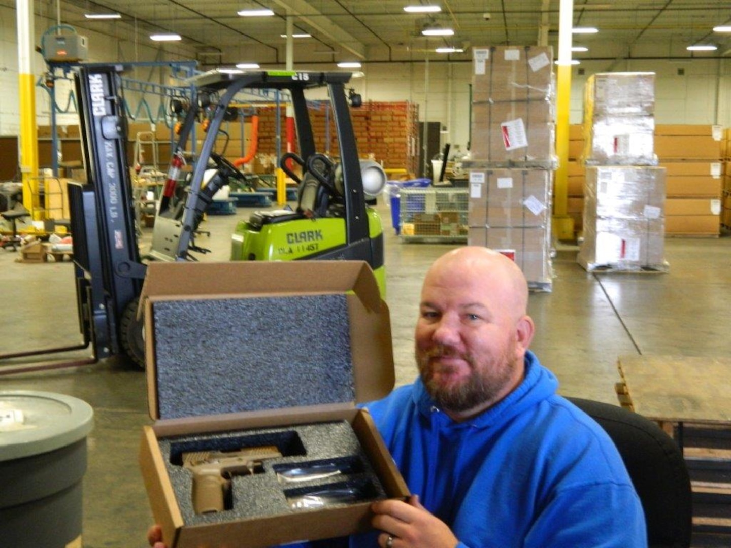 Jarred Slaton, DDAA warehouse packer, displays the pistol in the packing box.