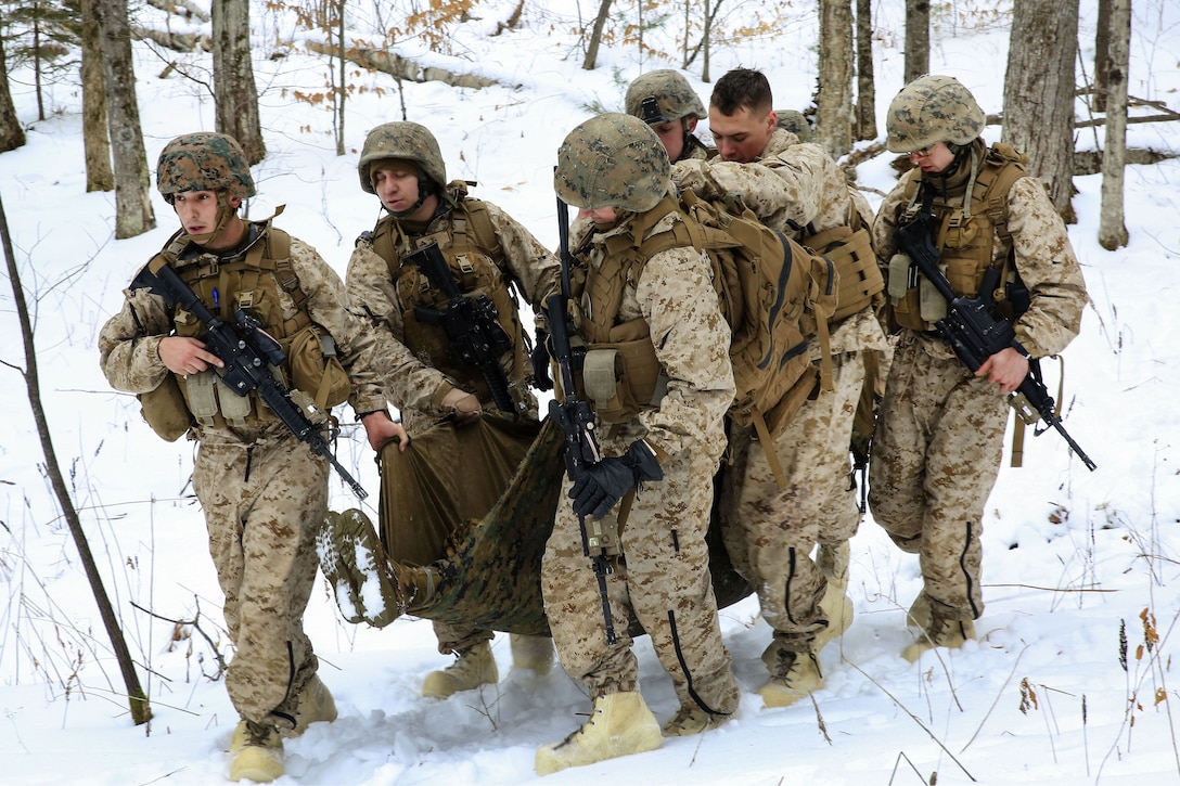 Marines transport a mock casualty using a poncho liner while conducting medical evacuation techniques.