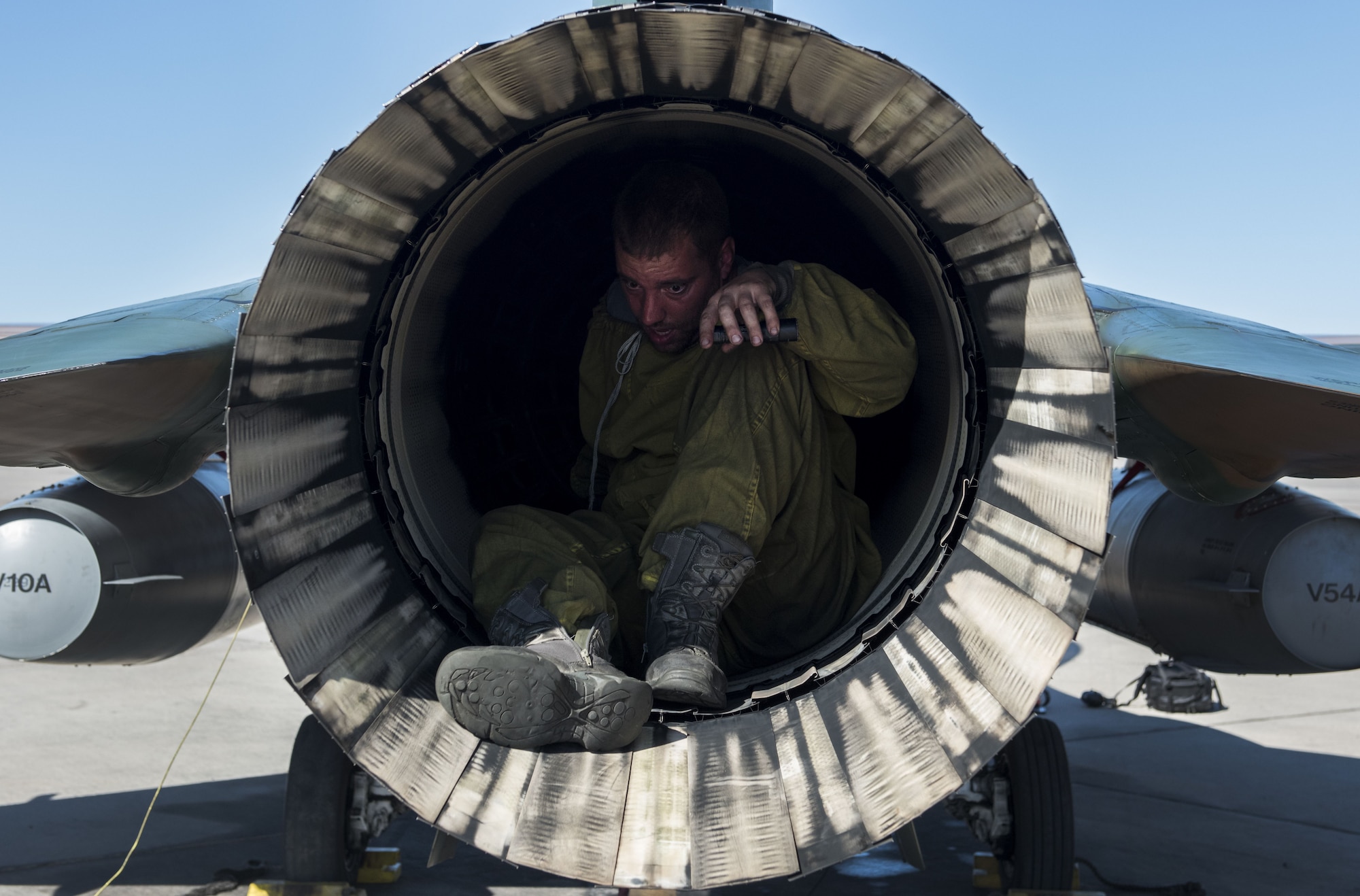 Staff Sgt. Michael Dalrymple, 57th Aircraft Maintenance Squadron crew chief, checks the exhaust of an F-16 Fighting Falcon on the flight line at Nellis Air Force Base, Nev., Aug. 25, 2017. Dalrymple is assigned to the Aggressors who are responsible for providing the opposing threat during training exercises at Nellis AFB. (U.S. Air Force photo by Senior Airman Kevin Tanenbaum)