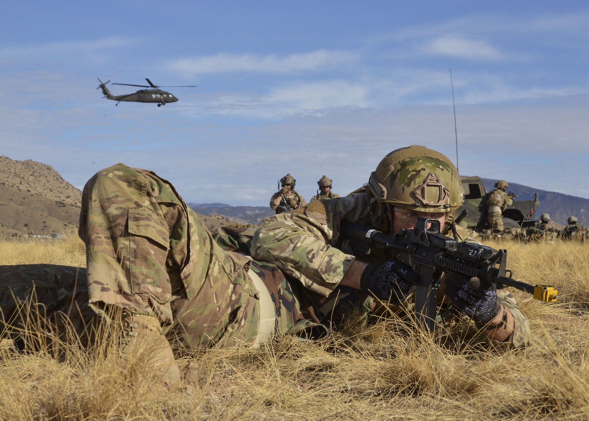 A student from the U.S. Air Force Pararescue School shields a wounded Airman while engaging in small arms fire during a mass casualty exercise Jan. 6, 2018 at Kirtland Air Force Base, N.M. The exercise, part of a sequence of full mission profiles pararescuemen and combat rescue officer students must face before graduation, included more than 100 Airmen and Soldiers. Members of the 3-501st Air Assault Brigade from Fort Bliss, Texas, provided the air component with UH-60 Blackhawk helicopters. (U.S. Air Force photo by Jim Fisher)
