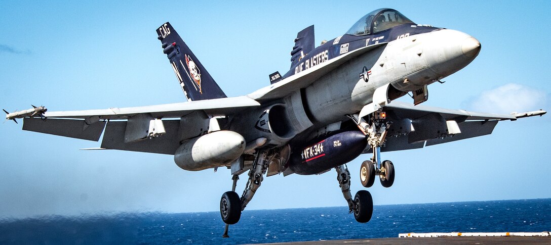 An F/A-18C Hornet aircraft lands on the flight deck of the Nimitz-class aircraft carrier USS Carl Vinson.