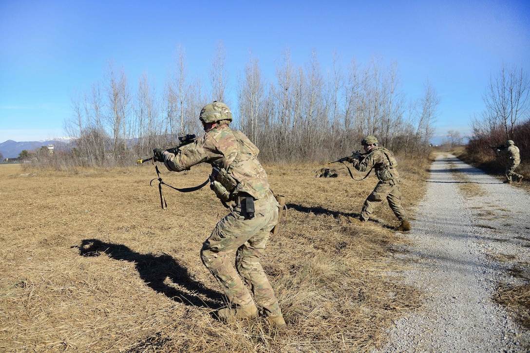 Paratroopers approach a fallen enemy combatant.