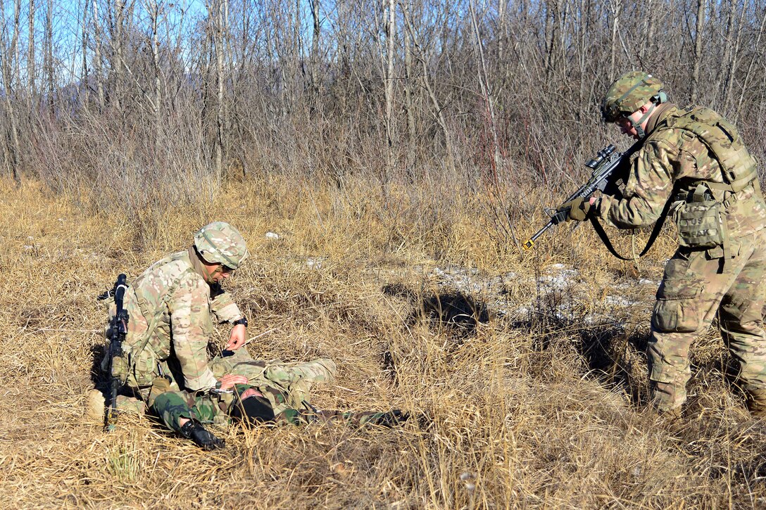 A soldier checks for injuries on an enemy combatant role-player.