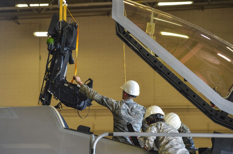 Airman 1st Class Matthew Romano, 56th Component Maintenance Squadron egress systems technician, guides an ejection seat out of the cockpit of an F-35A Lightning II at Luke Air Force Base, Ariz., Jan. 11, 2018. The F-35 Joint Program Office worked with contractors and Martin-Baker, the manufacturer of the ejection seat, to lift weight limit restrictions. (U.S. Air Force photo/Airman 1st Class Caleb Worpel)