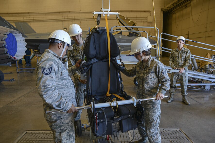 Airmen assigned to the 56th Component Maintenance Squadron guide an F-35A Lightning II ejection seat onto a cart for maintenance at Luke Air Force Base, Ariz., Jan. 11, 2018. In May 2017, three modifications were implemented to the F-35 ejection system to remove the 136 pound weight limit restriction. (U.S. Air Force photo/Airman 1st Class Caleb Worpel)