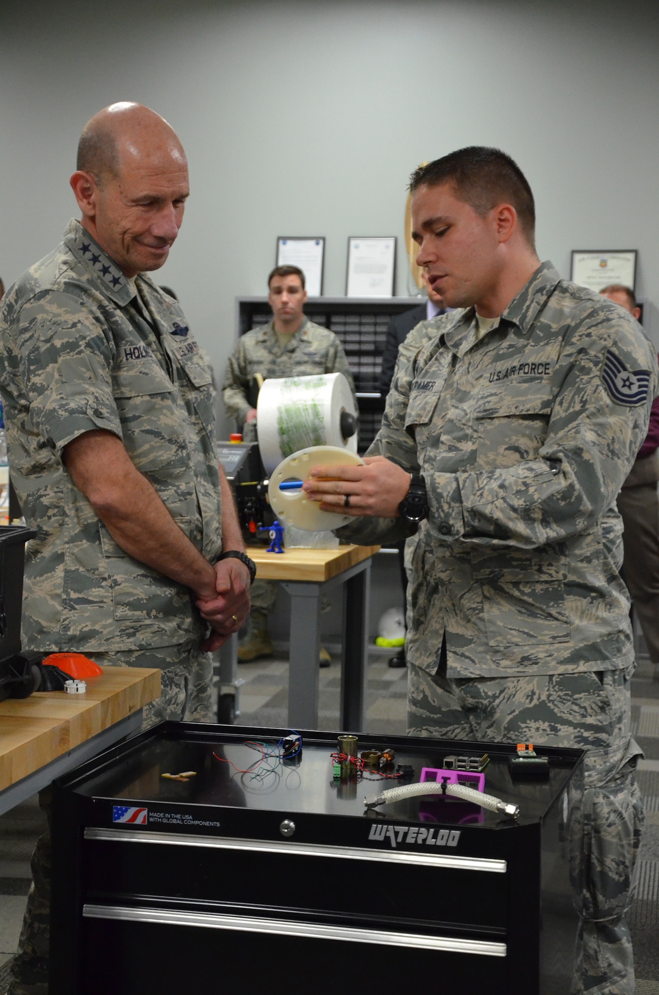 Tech. Sgt. Donald E. Kramer II, noncommissioned officer in charge of Innovation Operations for the Air Force Technical Applications Center, shows Gen. Mike Holmes, commander of Air Combat Command, a prototype of an early iteration of a materials program carousel created by AFTAC's Innovation Lab.  This was Holmes' first visit to the Department of Defense's sole nuclear treaty monitoring center at Patrick AFB, Fla.  (U.S. Air Force photo by Susan A. Romano)