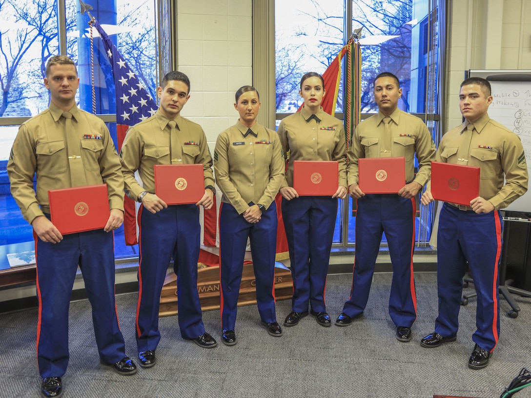 Marines pose for photo, with Sgt. Brittany Keiter, the noncommissioned officer in charge for Corporals Course, after the Corporals Course 1-18 graduation at Naval Station Great Lakes, Ill., Jan. 26. Corporals spread across the Midwest gathered here to take part in the three-week course where they learned everything from sword and guidon manual, combat conditioning, personal and professional communication, foundations of Marine Corps leadership, career progression and much more. (Photo by U.S Marine Corporal Quavaungh Pointer)