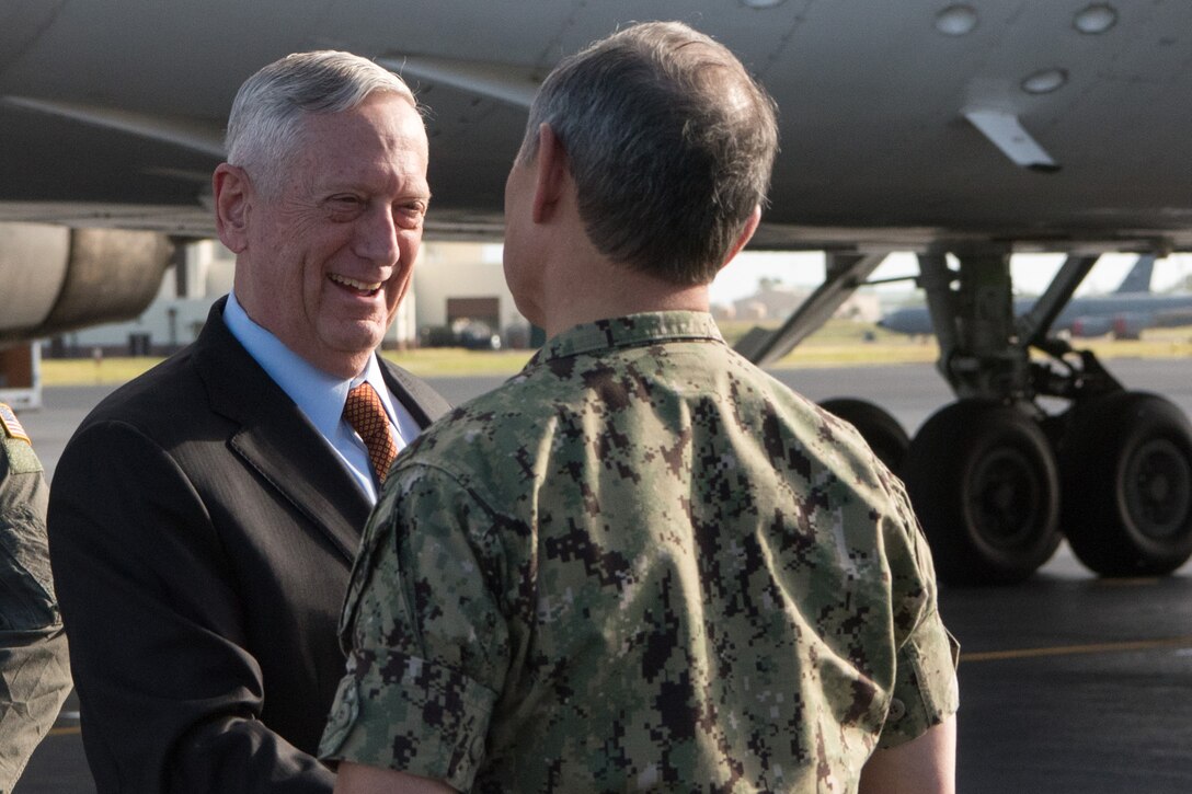 Defense Secretary James N. Mattis stands with a sailor on a runway.