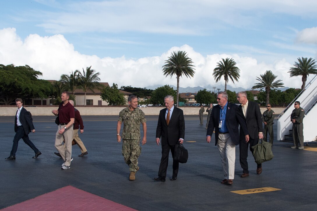 Defense Secretary James N. Mattis is greeted on a runway.
