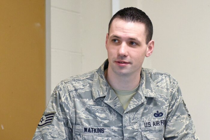 An airman stands behind a podium.