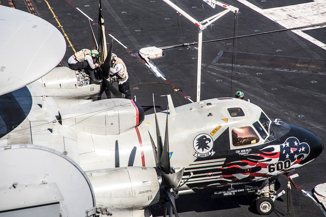 Sailors perform maintenance on an E-2C Hawkeye.