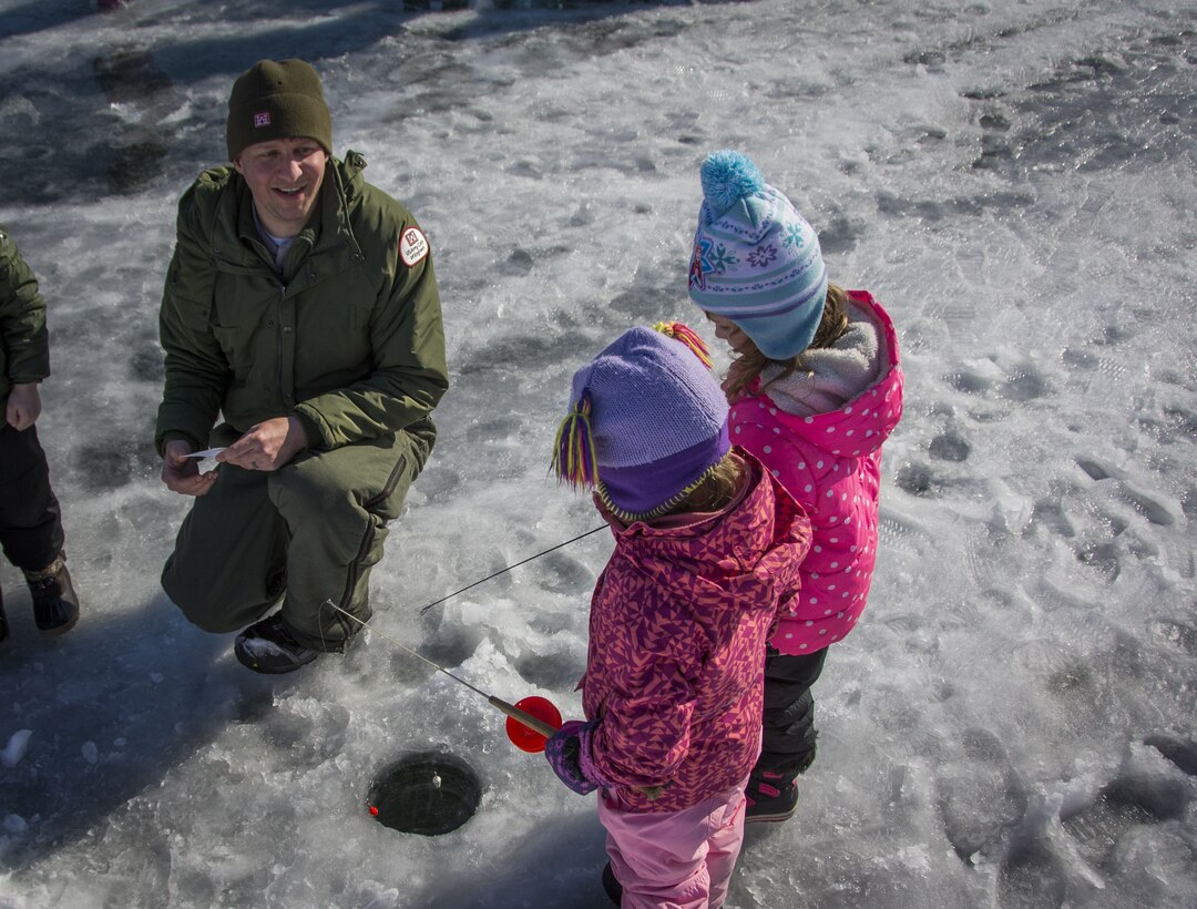 Brad LaBadie, Eau Galle Recreation Area park ranger, lends a few words of advice to two aspiring ice fisherwomen on Eau Galle Lake, Wisconsin, on Jan. 26, 2018. The anglers were part of an annual Spring Valley Elementary field trip that included interactive classroom training to include water safety and "purchasing" a fishing license. LaBadie played out his role by "inspecting" the anglers' licenses.