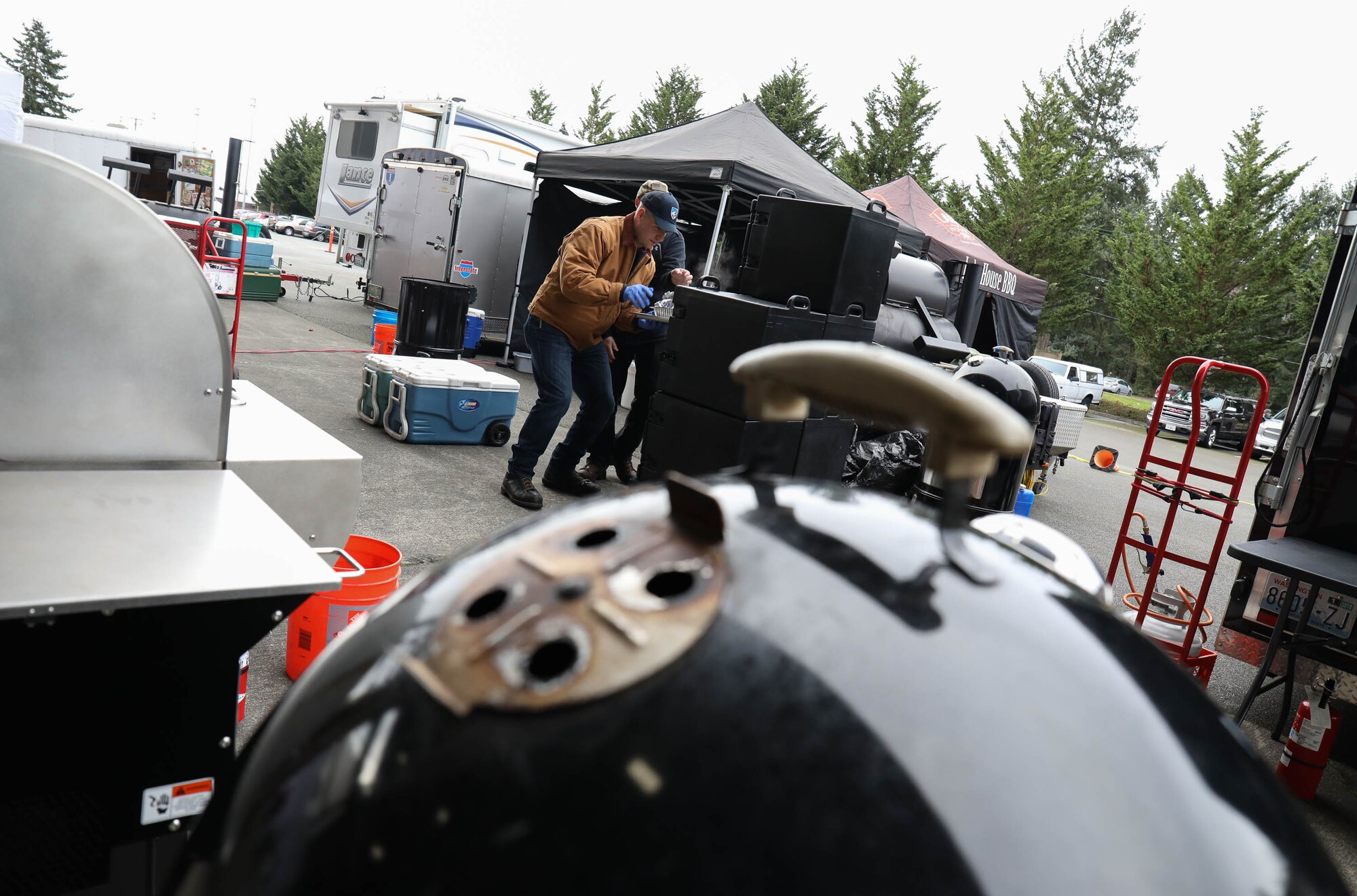 Scott Plocar and Tech. Sgt. John Hillenbrand of the 446th Airlift Wing transfer a pork butt to rest before slicing Jan. 19, 2018, on Joint Base Lewis-McChord. As a part of Diversity Day, Airmen of the 62nd and 446th Airlift Wings competed in a barbecue competition with free barbecue served to personnel assigned to JBLM.
