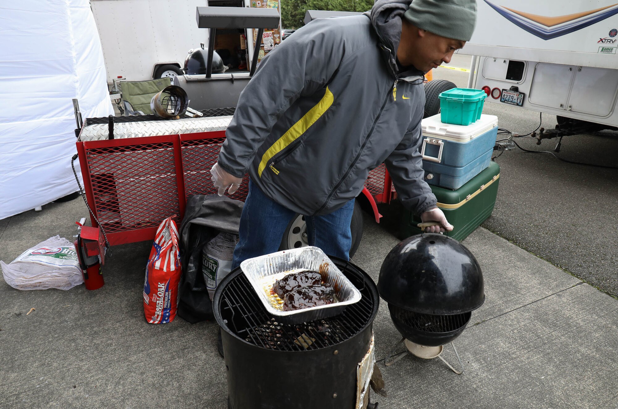 Master Sgt. Juan Naputi finishes preparations on a piece of barbecue that will be judged in a barbecue competition Jan. 19, 2018, on Joint Base Lewis-McChord. The completion was a part of Diversity Day where Airmen of the 62nd and 446th Airlift Wings paired with Washington State pitmasters.
