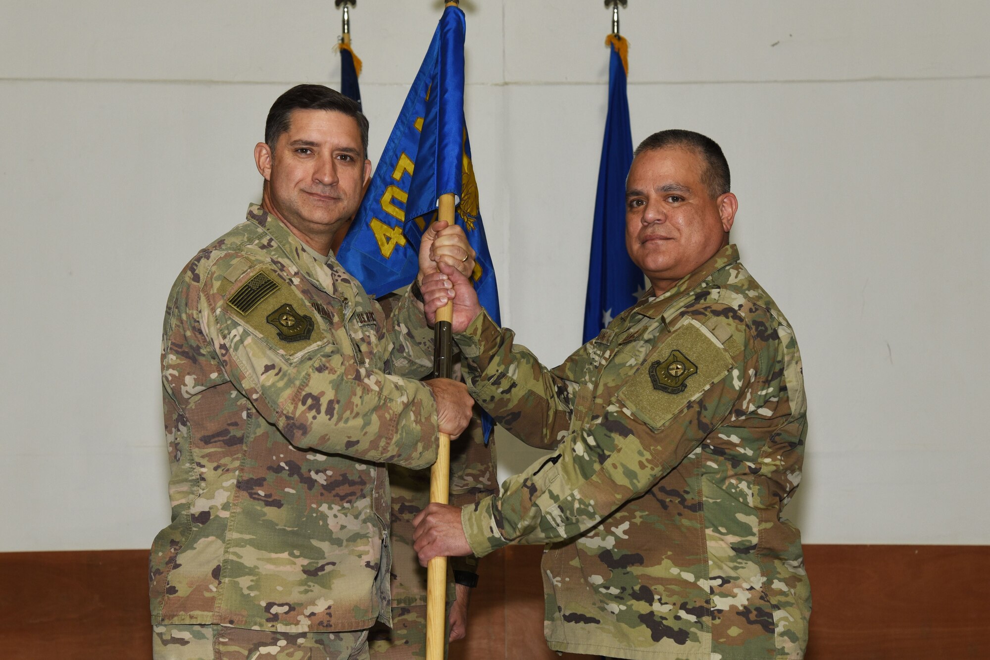 U.S. Air Force Col. John Gonzales, 407th Air Expeditionary Group Commander, passes a guidon to Lt. Col. John Marang, 407th Expeditionary Logistics Readiness Squadron Commander, in Southwest Asia, January 25, 2018. The change of command ceremony is a time honored military tradition that signifies the orderly transfer of authority. (U.S. Air Force photo by Staff Sgt. Joshua Edwards/Released)