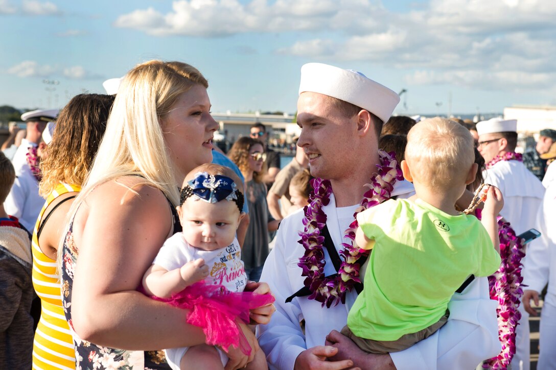 A sailor is greeted by his family following the change of home port of the fast-attack submarine USS Missouri.