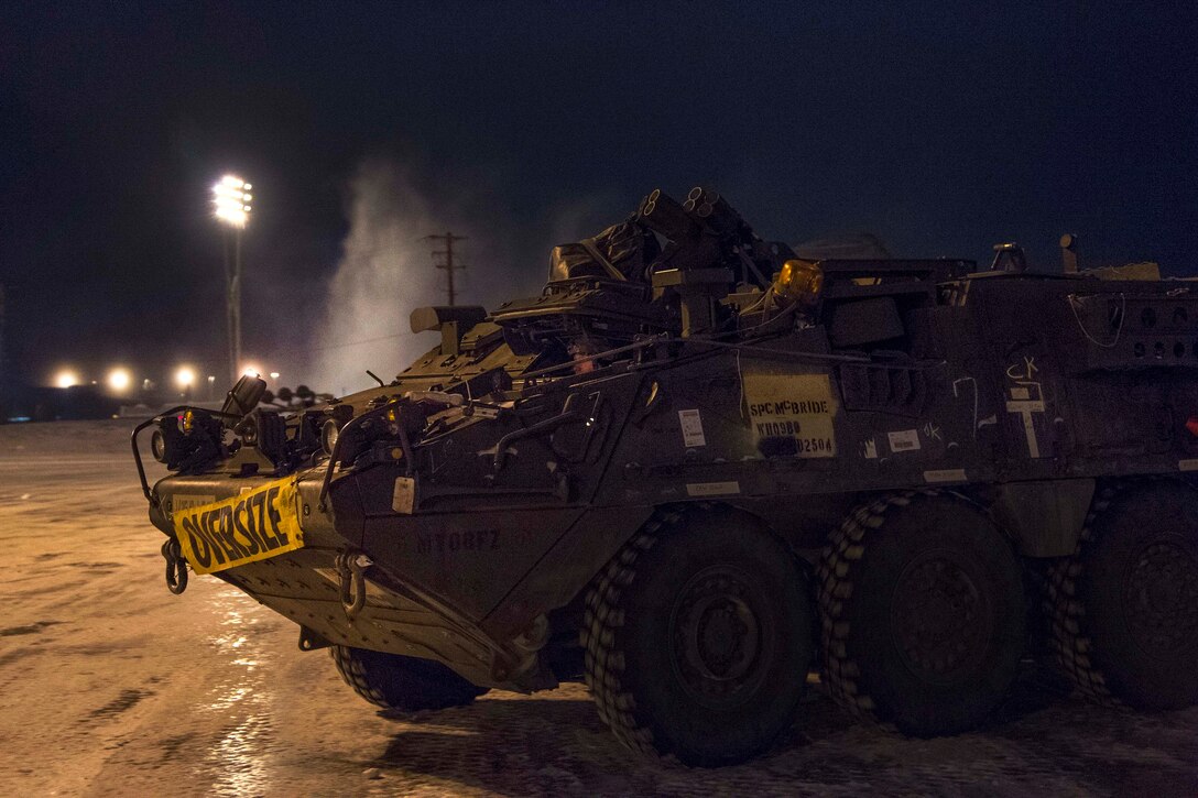 Soldiers drive an Army Stryker vehicle off the flight line.