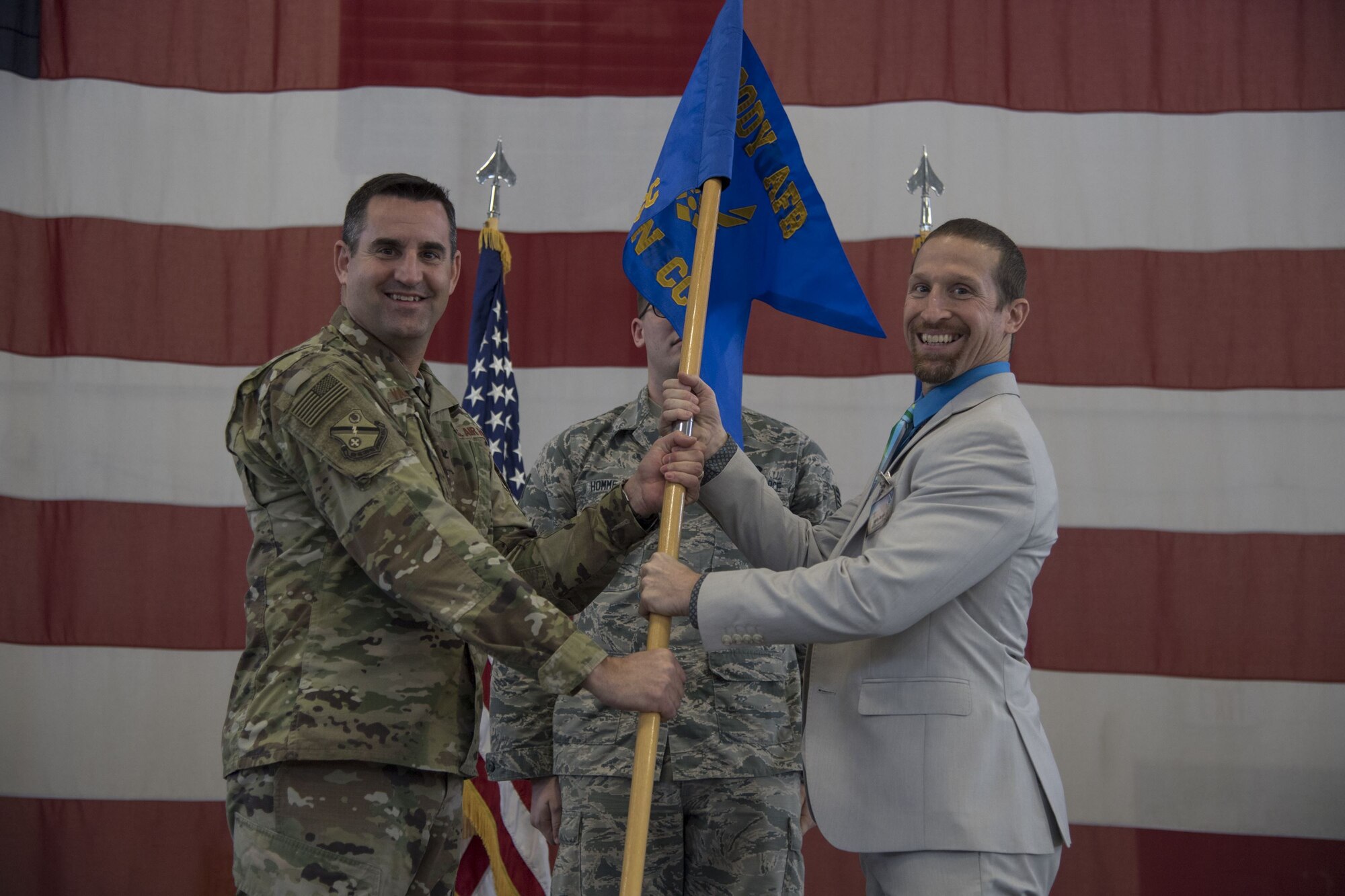 Col. Jeffrey Valenzia, 93d Air Ground Operations Wing commander, hands the guidon to Kelly Barcol, incoming 93d AGOW honorary commander, during an Honorary Commander Change of Command ceremony at Moody Air Force Base, Ga., Jan. 26, 2018. The Honorary Commander Program allows local community leaders to gain awareness of Moody’s mission through official and social functions. (U.S. Air Force Photo by Staff Sgt. Olivia Dominique)