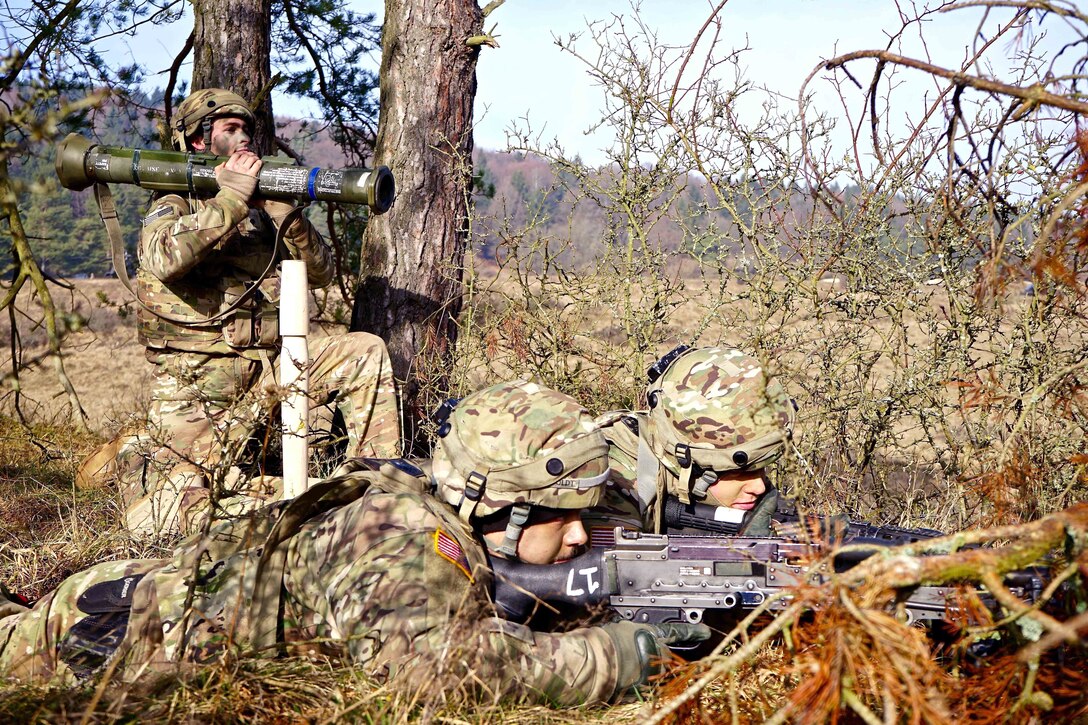 Three soldiers aiming weapons in a wooded area.