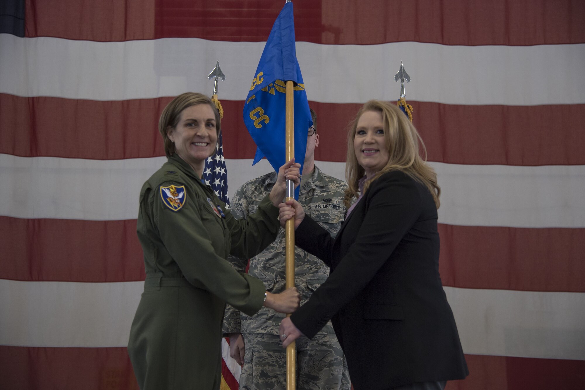 Col. Jennifer Short, 23d Wing commander, hands Paige Dukes, incoming 23d WG honorary commander, the guidon during an Honorary Commander Change of Command ceremony at Moody Air Force Base, Ga., Jan. 26, 2018. The Honorary Commander Program allows local community leaders to gain awareness of Moody’s mission through official and social functions. (U.S. Air Force photo by Staff Sgt. Olivia Dominique)
