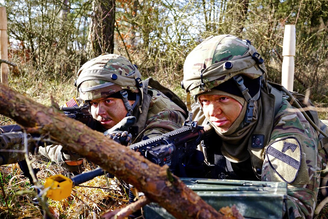 Two soldiers in a wooded area.