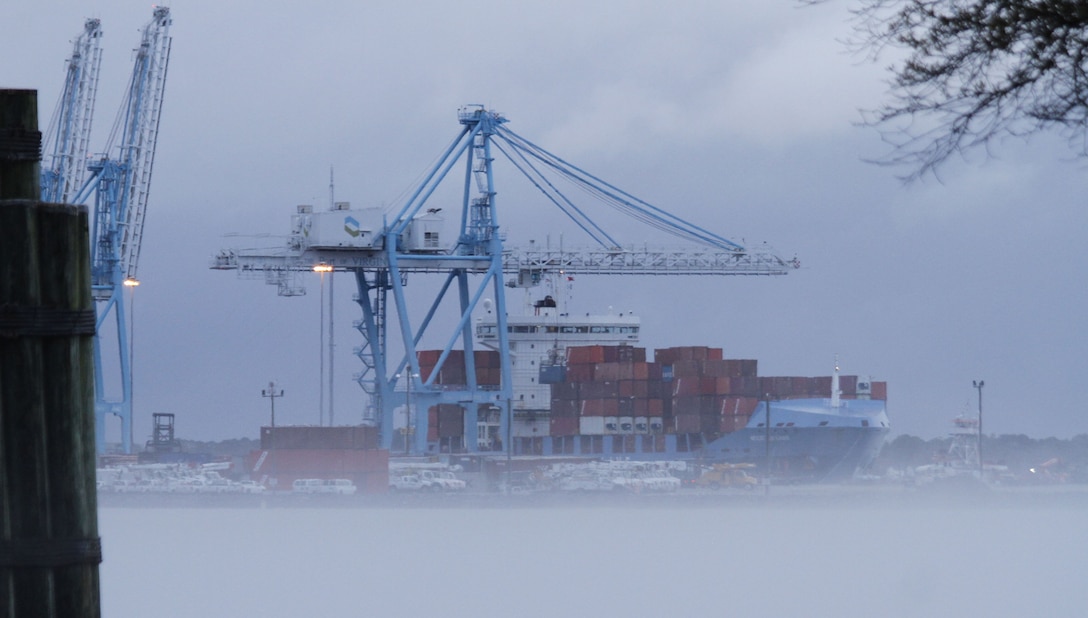 Fog settles in along the Elizabeth River as cranes offload cargo from a ship docked at the Portsmouth Marine Terminal in Portsmouth, Virginia.