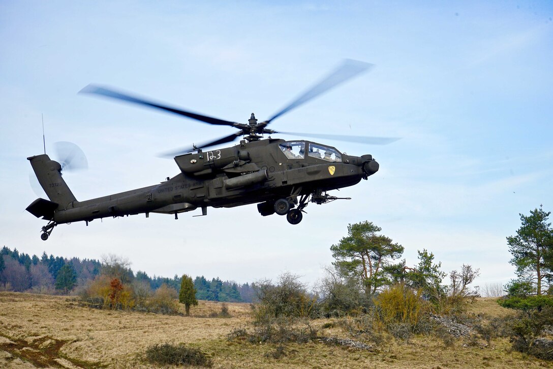 An AH-64 Apache attack helicopter takes off from the tactical airfield.