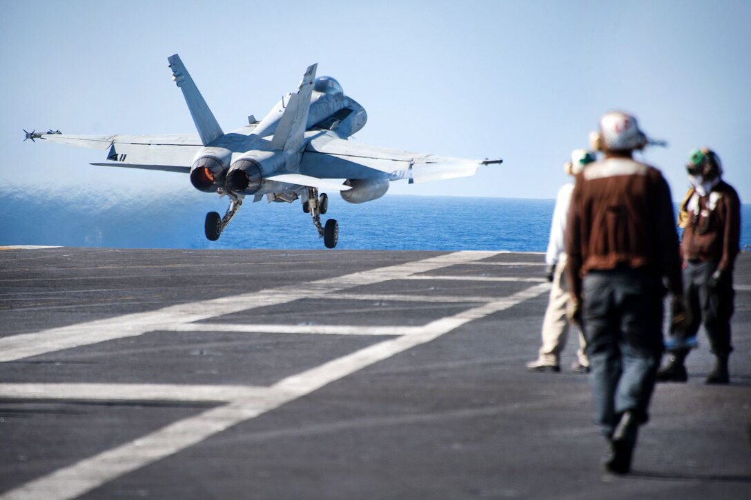 A military aircraft takes off from the flight deck of Nimitz-class aircraft carrier USS Carl Vinson.