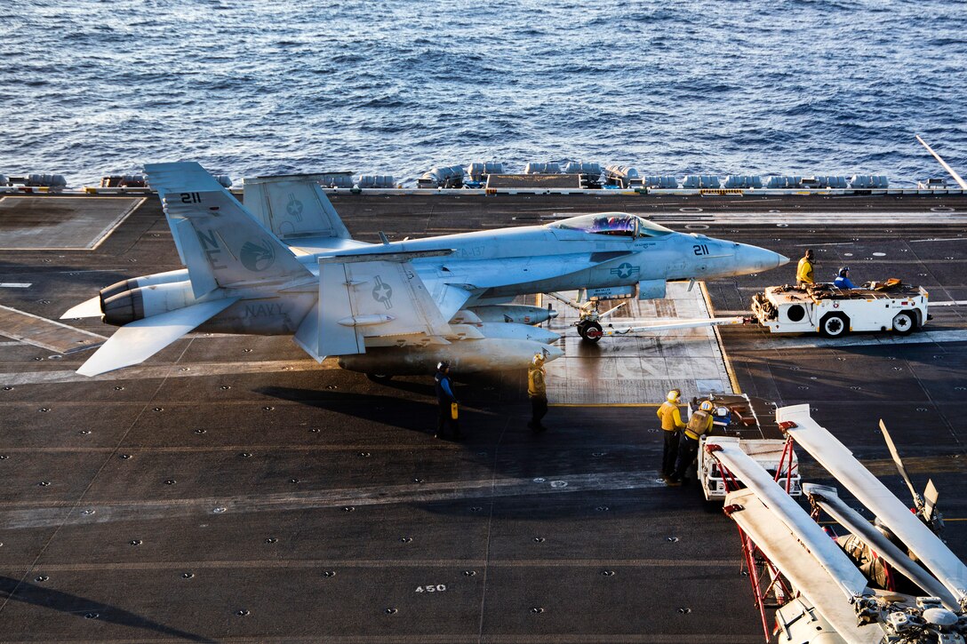 A military aircraft taxies across the flight deck of the aircraft carrier USS Carl Vinson.