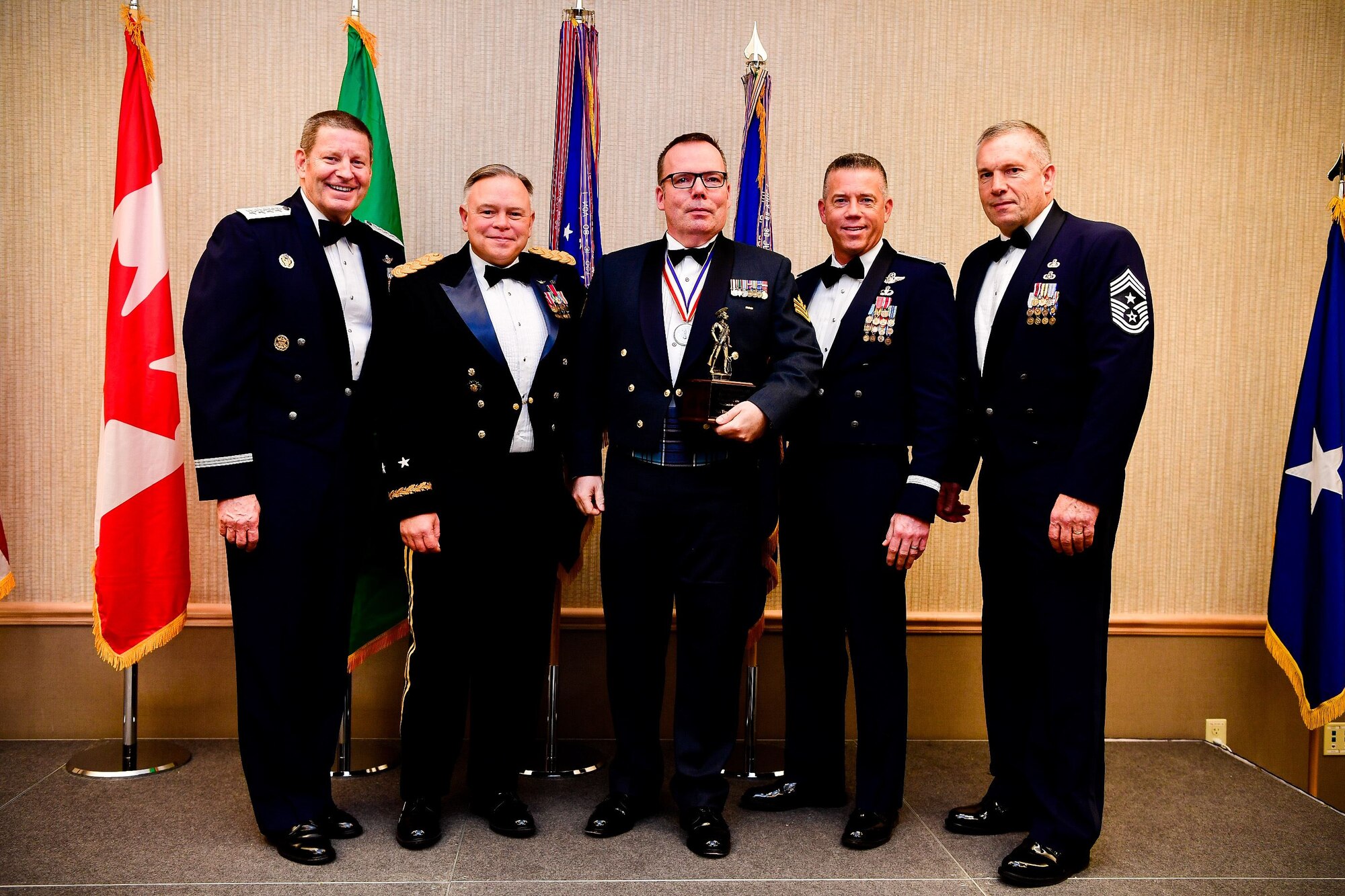 Royal Canadian Air Force Sgt. Yves Truchon, a command and control battle manager with the 225th Air Defense Squadron and Canadian Detachment, Western Air Defense Sector, is presented with the Honor Guard Manager of the Year trophy at the Washington Air National Guard’s 9th Annual Awards Banquet held at the American Lake Conference Center on Joint Base Lewis-McChord, Washington, Jan 27, 2018. Truchon was awarded the trophy for his outstanding contributions to the Washington Air National Guard over the last year.  Pictured from left to right are: Gen. Robin Rand, Air Force Global Strike Command and Air Forces Strategic-Air, U.S. Strategic Command commander, Maj. Gen. Bret Daugherty, Adjutant General of the Washington National Guard, Truchon, Brig. Gen. Jeremy Horn, commander of the Washington Air National Guard, and Chief Master Sgt. Max Tidwell, Washington Air National Guard command chief. (U.S. Air National Guard photo by Tech. Sgt. Timothy Chacon)
