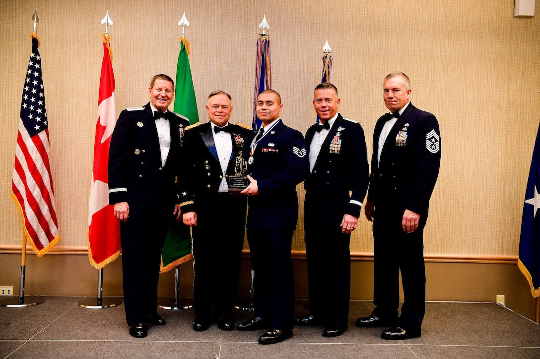 Staff Sgt. Christopher LaCour, a cyber systems operations journeyman with the 225th Support Squadron, Western Air Defense Sector, is presented with the Airman of the Year trophy at the Washington Air National Guard’s 9th Annual Awards Banquet held at the American Lake Conference Center on Joint Base Lewis-McChord, Washington, Jan. 27, 2018.  LaCour was awarded the trophy for his outstanding contributions to the Washington Air National Guard over the last year.  Pictured from left to right are: Gen. Robin Rand, Air Force Global Strike Command and Air Forces Strategic-Air, U.S. Strategic Command commander; Maj. Gen. Bret Daugherty, Adjutant General of the Washington National Guard, LaCour, Brig. Gen. Jeremy Horn, commander of the Washington Air National Guard, and Chief Master Sgt. Max Tidwell, WA ANG command chief. (U.S. Air National Guard photo by Tech. Sgt. Timothy Chacon)